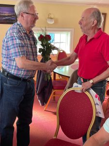 Med ett fång blommor gratulerades 80-åringen Ingvar Ellnestam (t v) av klubbens president Bengt-Sture Skånehult.